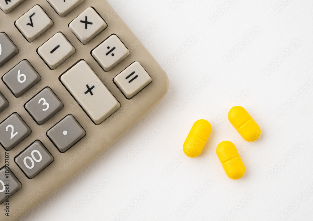 Calculator and pills on white background Calculator and pills on white background