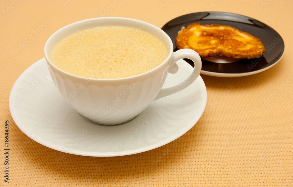 Closeup of coffee with milk in white cup and a palmier pastry