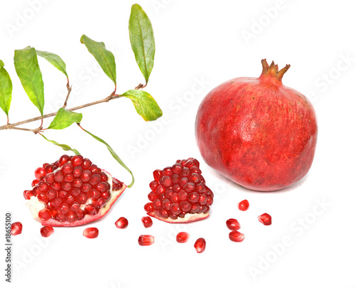 Pomegranate and segments and twig isolated on white background