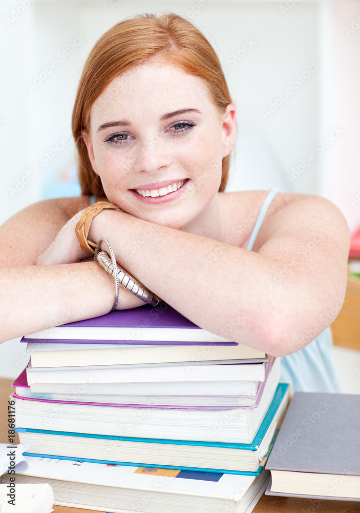 Smiling teeenager studying lots of books Smiling teeenager studying lots of books