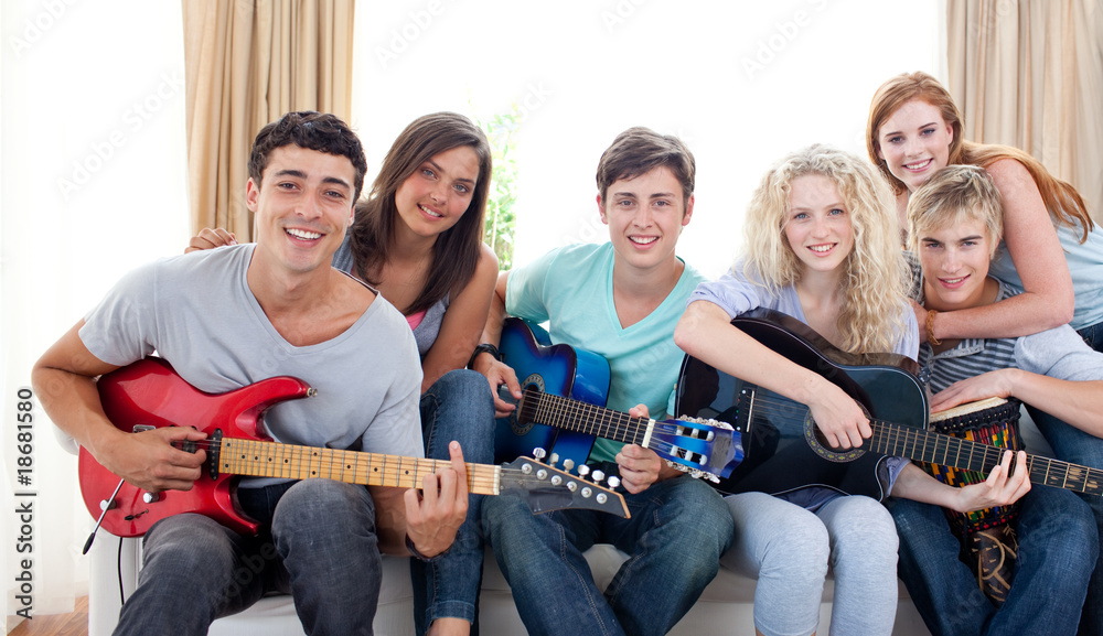 Obraz premium Group of teenagers playing guitar at home