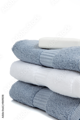 Gray blue and white towels with soap on white with copy space