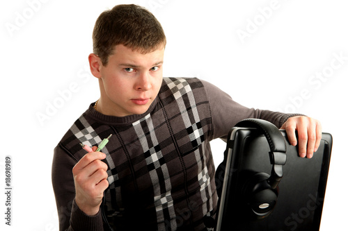 Young man from the headphone cord connects to a laptop