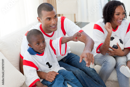 Excited Afro-American family wathing a football match photo