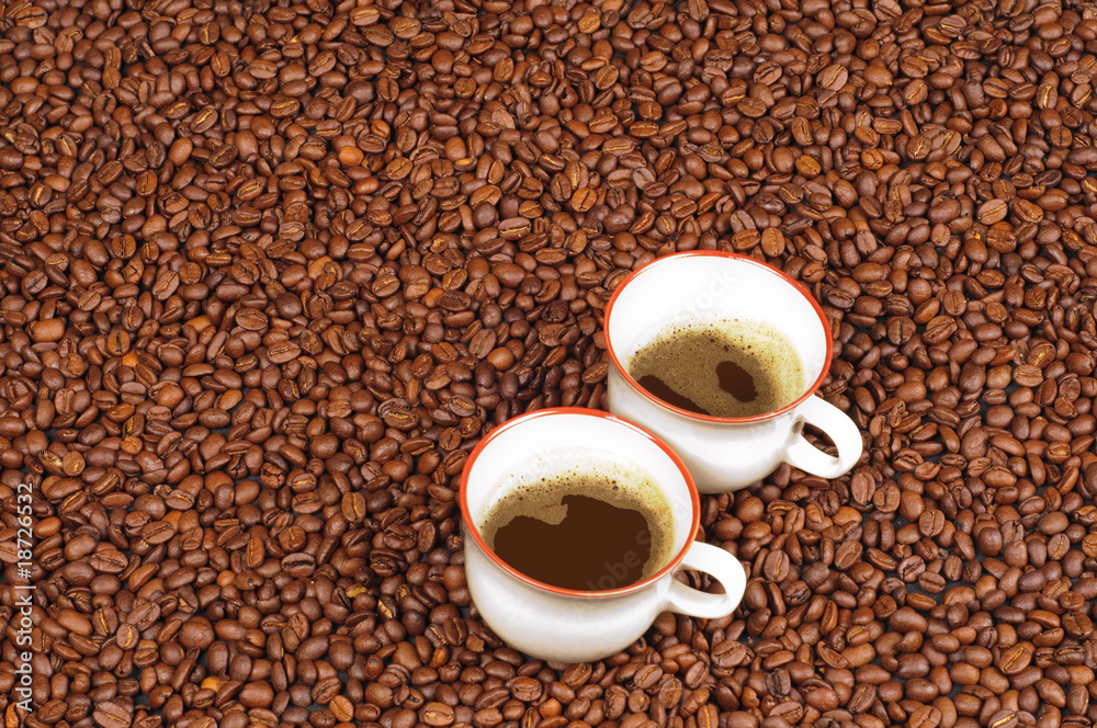 Two cups of coffee an a background of roasted coffee beans Two cups of coffee an a background of roasted coffee beans