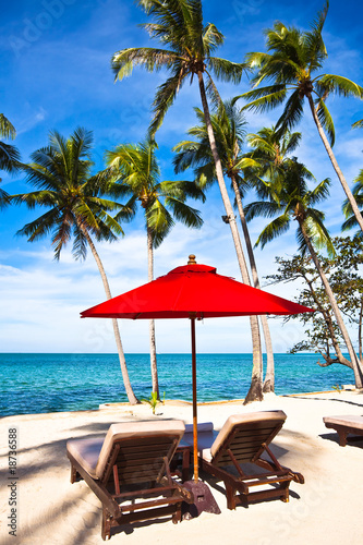 Fototapeta Naklejka Na Ścianę i Meble -  Red umbrella and chairs on sand beach in tropic