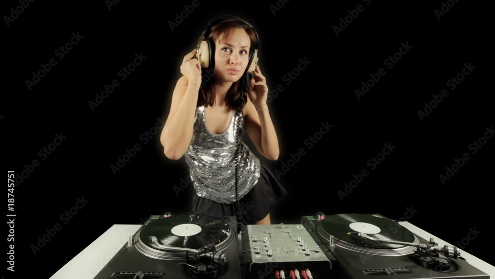 beautiful young female dj, behind the decks at a club