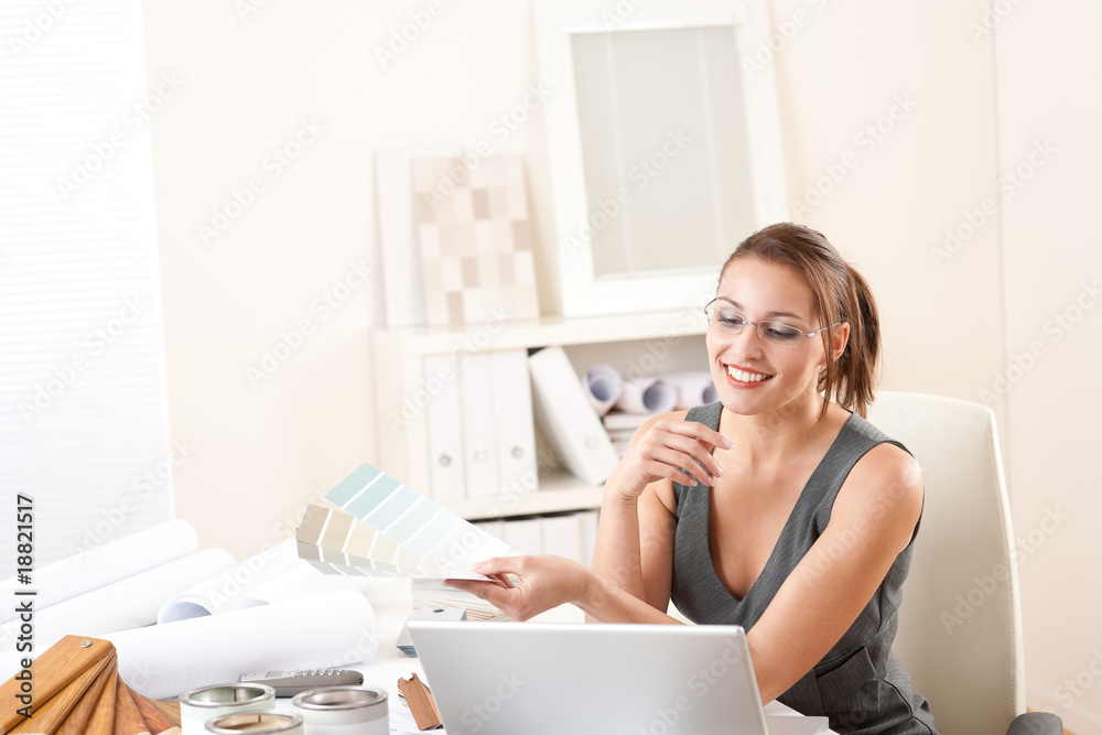 Young female designer working at office with laptop Young female designer working at office with laptop
