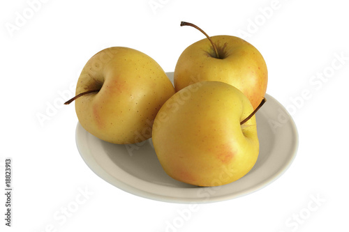 Three yellow apples on white plate