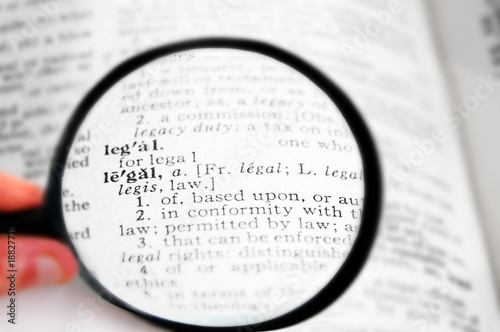 closeup of the word Legal in a dictionary  with magnifying glass