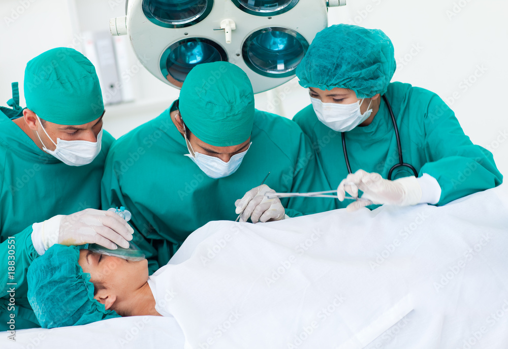 Surgeons near patient lying on an operating table Surgeons near patient lying on an operating table