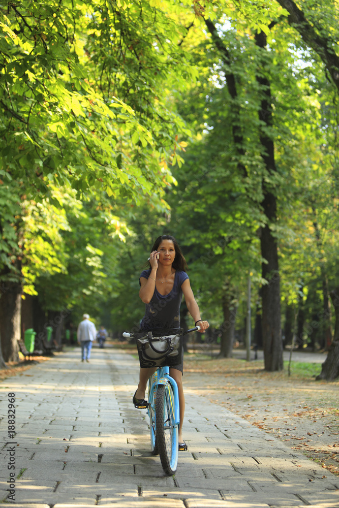Woman on the phone riding bicycle