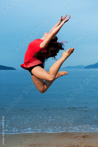Fototapeta Naklejka Na Ścianę i Meble -  Beautiful young woman jumping in the sea ....