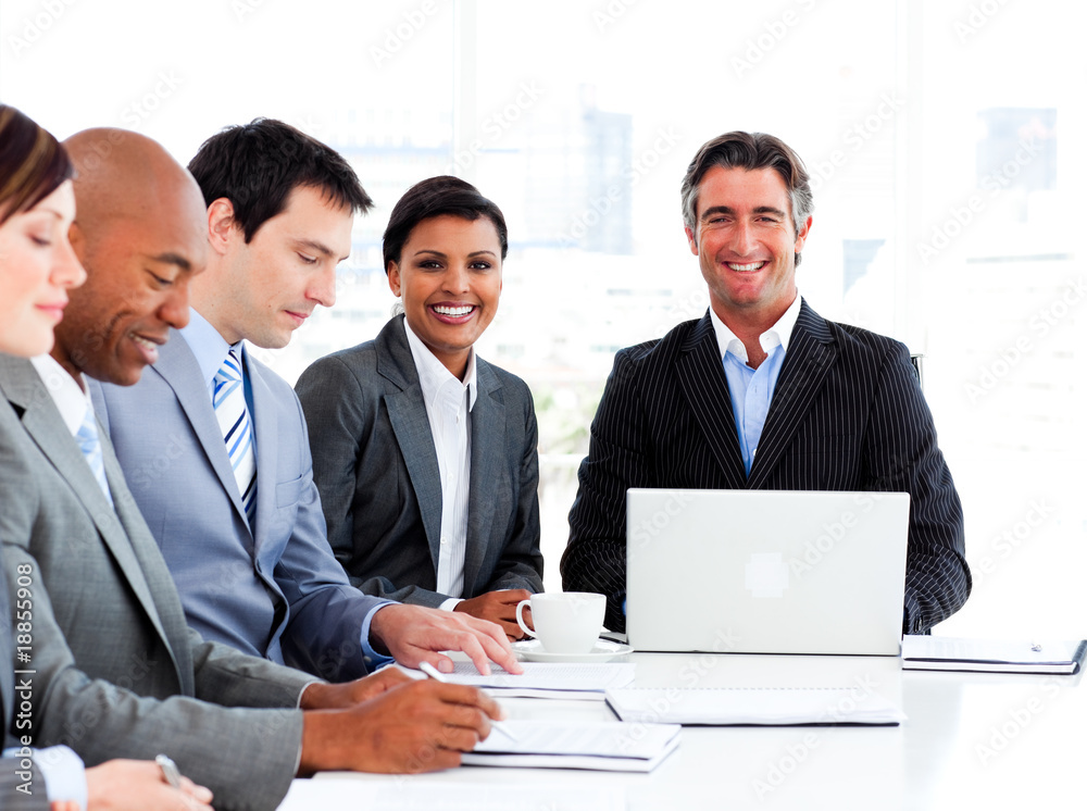 Manager usimg a laptop in a meeting with his team Manager usimg a laptop in a meeting with his team