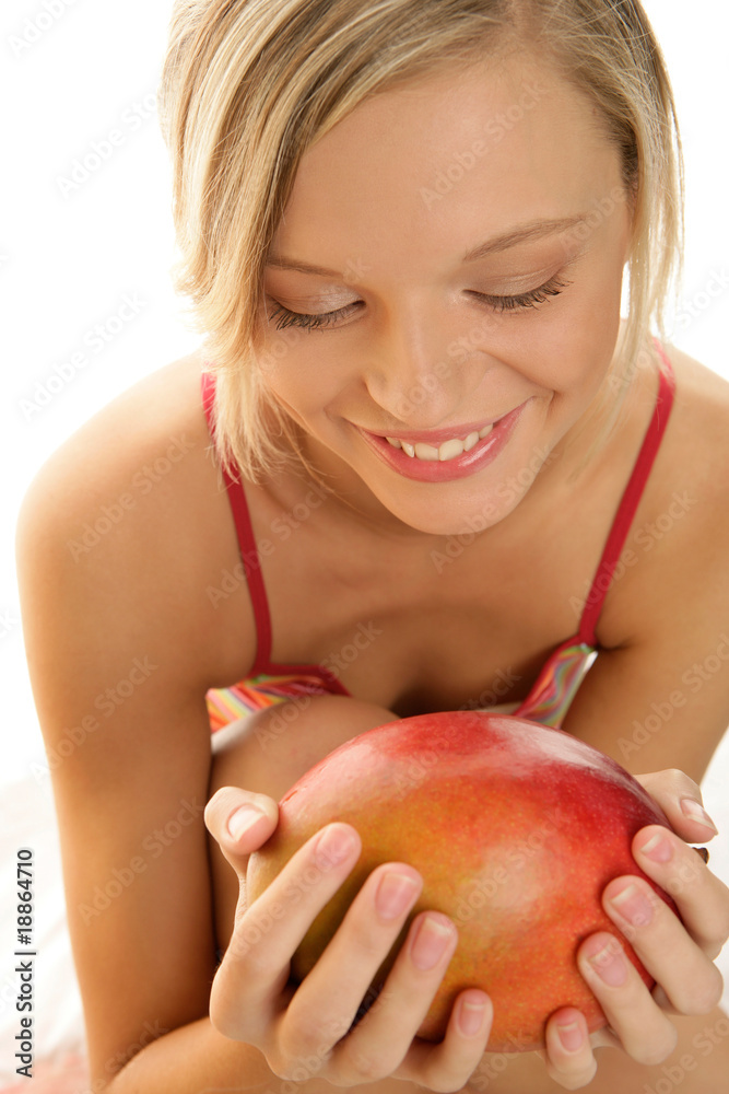 Happy young woman holding ripe mango Happy young woman holding ripe mango