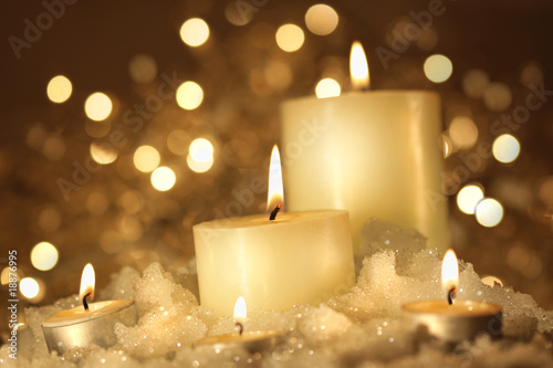 Brightly lit candles in wet snow