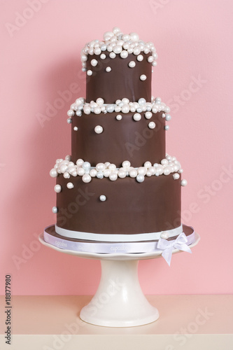 Three-tiered Chocolate Cake Against Pink Background
