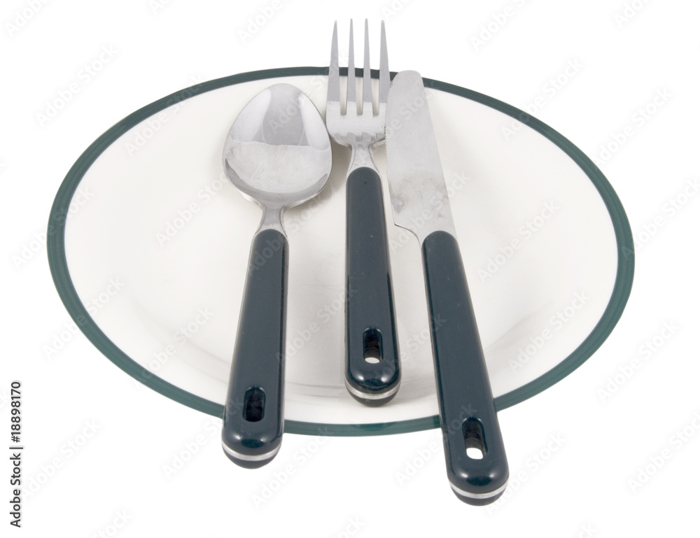 Fototapeta premium knifr, fork and spoon on green ringed plate on white