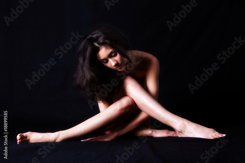 girl sitting against black background