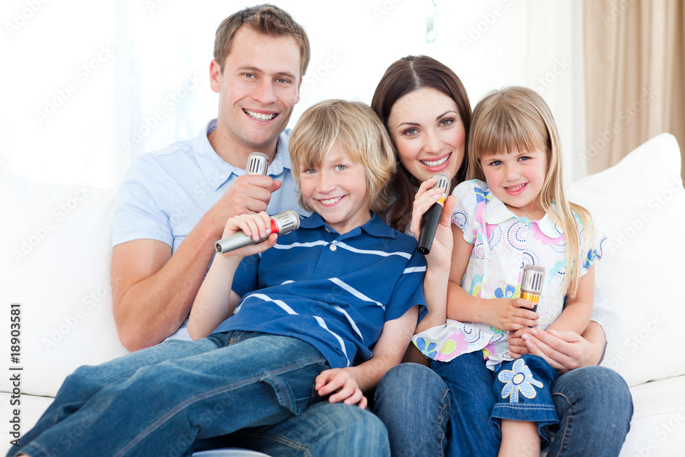 Smiling young family singing a karaoke together Smiling young family singing a karaoke together
