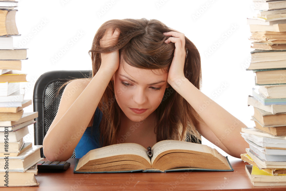 Teenage girl studying at the desk being tired Teenage girl studying at the desk being tired