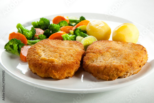 Fried pork chop with boiled potatoes and vegetables
