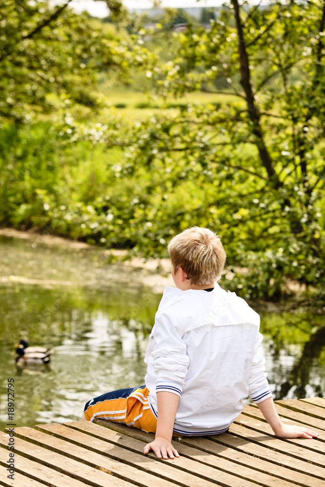 Portrait of young boy sitting on a bridge Portrait of young boy sitting on a bridge