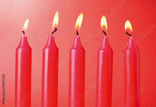 Five Red Candles on red background.