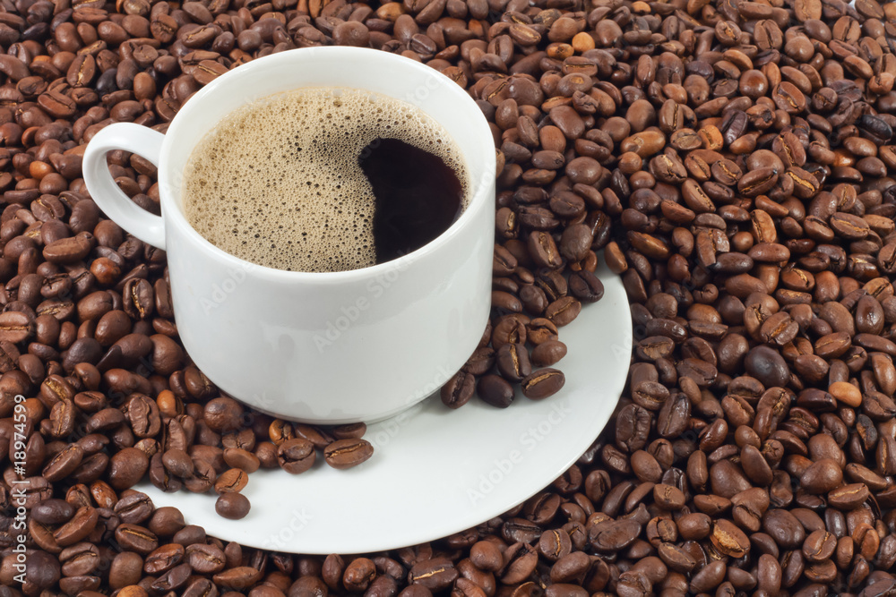 cup of coffee over a lot of coffee beans cup of coffee over a lot of coffee beans