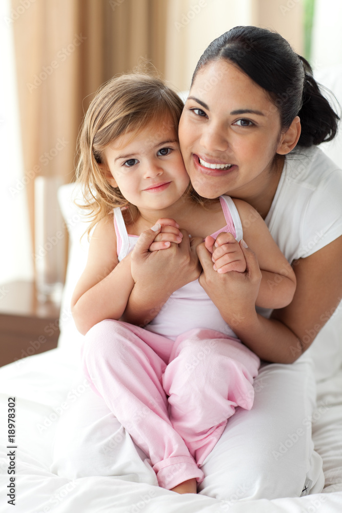 Smiling mother hugging her little girl