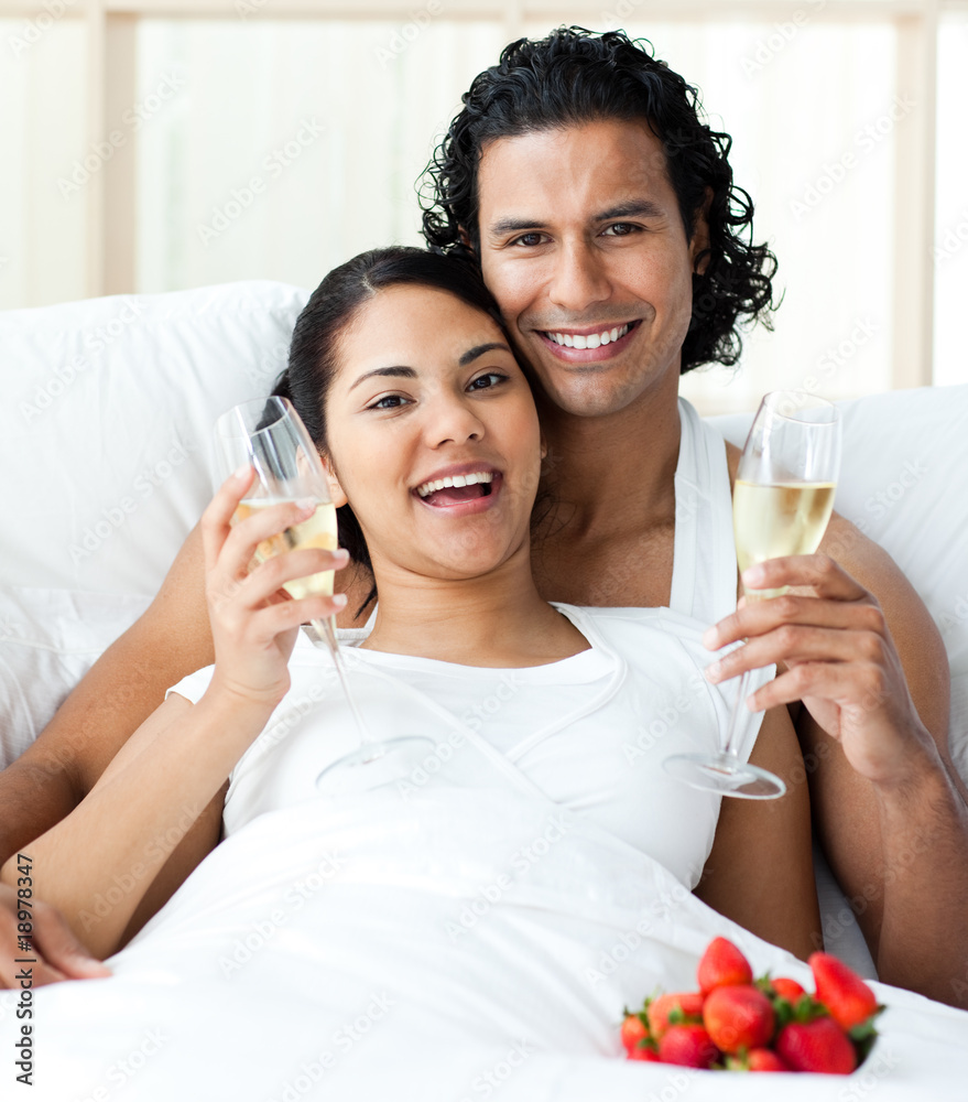 Happy young lovers drinking Champagne with strawberries Happy young lovers drinking Champagne with strawberries