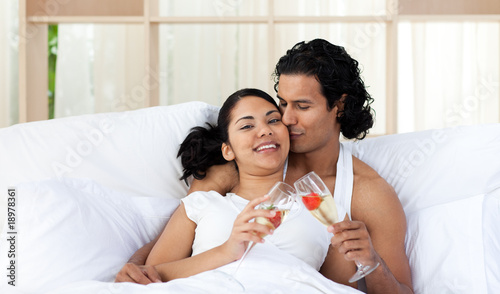 Lover kissing his wife while toasting with Champagne