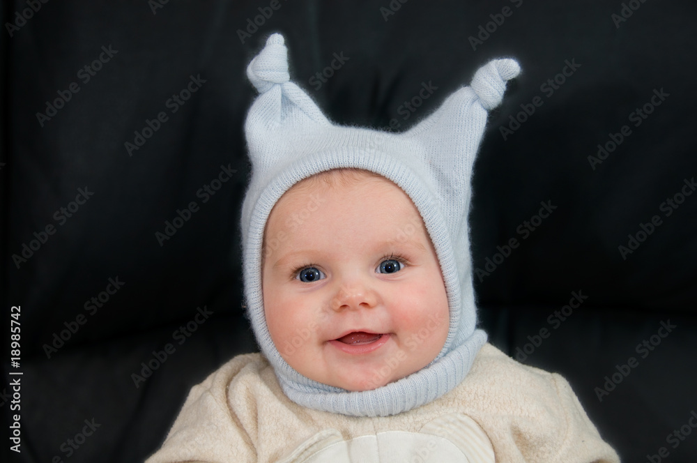Smiling child with funny hat sitting on the couch Smiling child with funny hat sitting on the couch