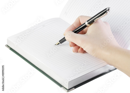 hand with pen writes in notebook