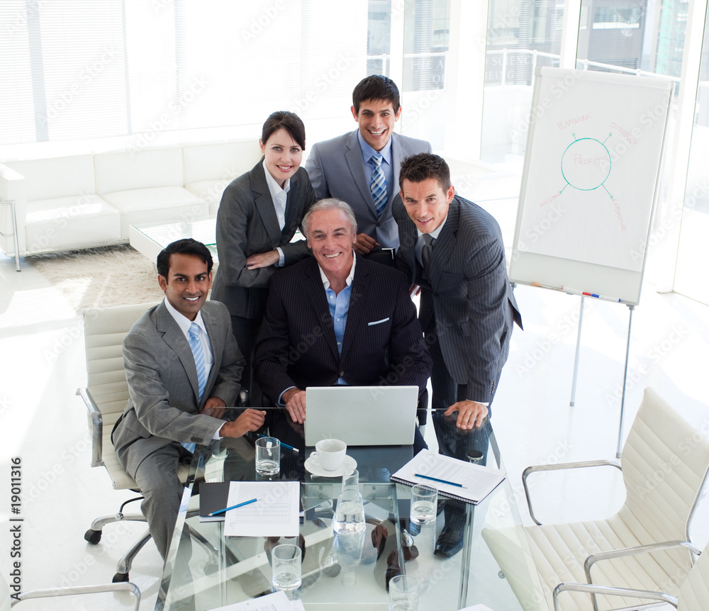 Senior businessman working with his team at a computer - obrazy, fototapety, plakaty 