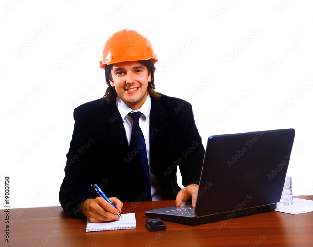 Construction contractor in the office on his laptop Construction contractor in the office on his laptop