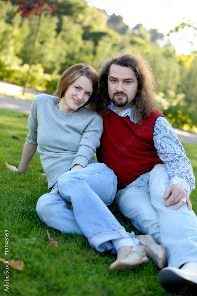 Young couple sitting on the grass in a park Young couple sitting on the grass in a park