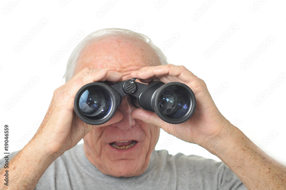 Man looks through binoculars into the distance Man looks through binoculars into the distance