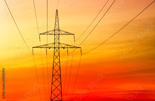 Electricity pylon at orange sunset photo