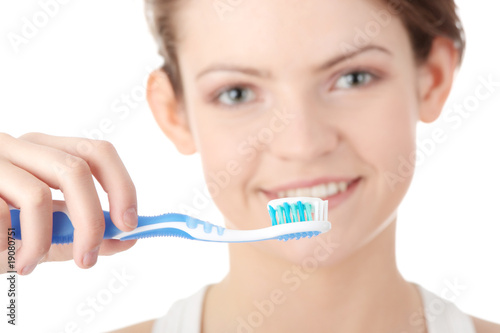 Young girl brushing her teeth happily