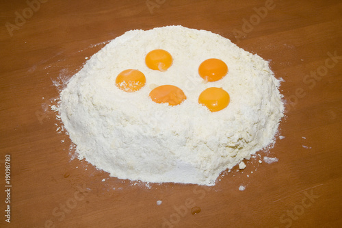 Flour and eggs on wooden table