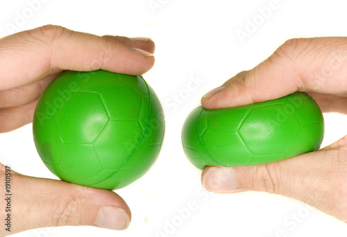 Quadro em tela a man's hand squeezing a green stress ball.