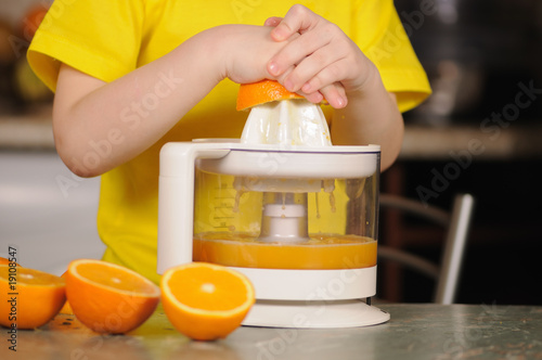 Foto The child to wring out juice