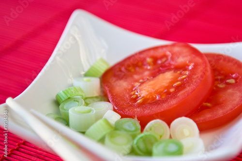 Tomate mit Porree in einer Schale mit Essstäbchen