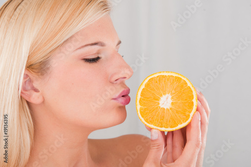 Young healthy smiling woman with citrus orange fruit