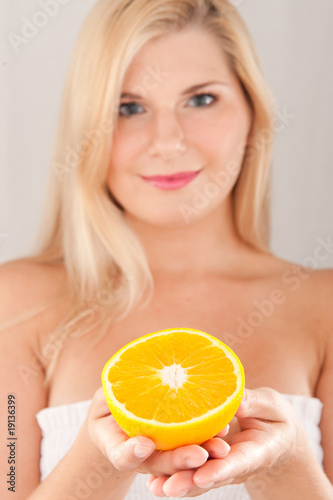 Young healthy smiling woman with citrus orange fruit