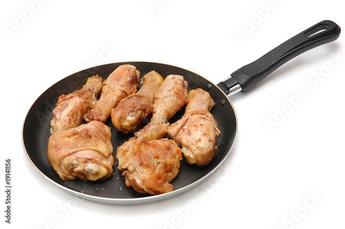 Roast chicken on a frying pan on a white background