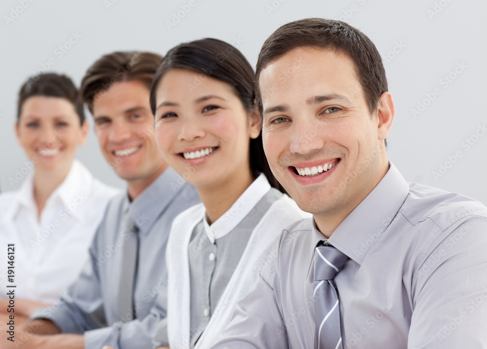 Young business people sitting in a line Young business people sitting in a line