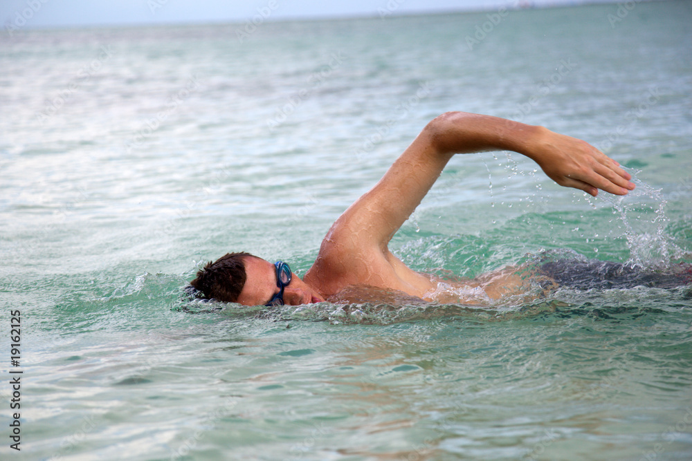 young man swiming in oceans water