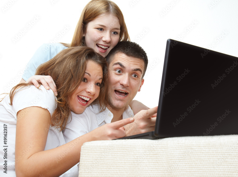 Happy young friends with a notebook